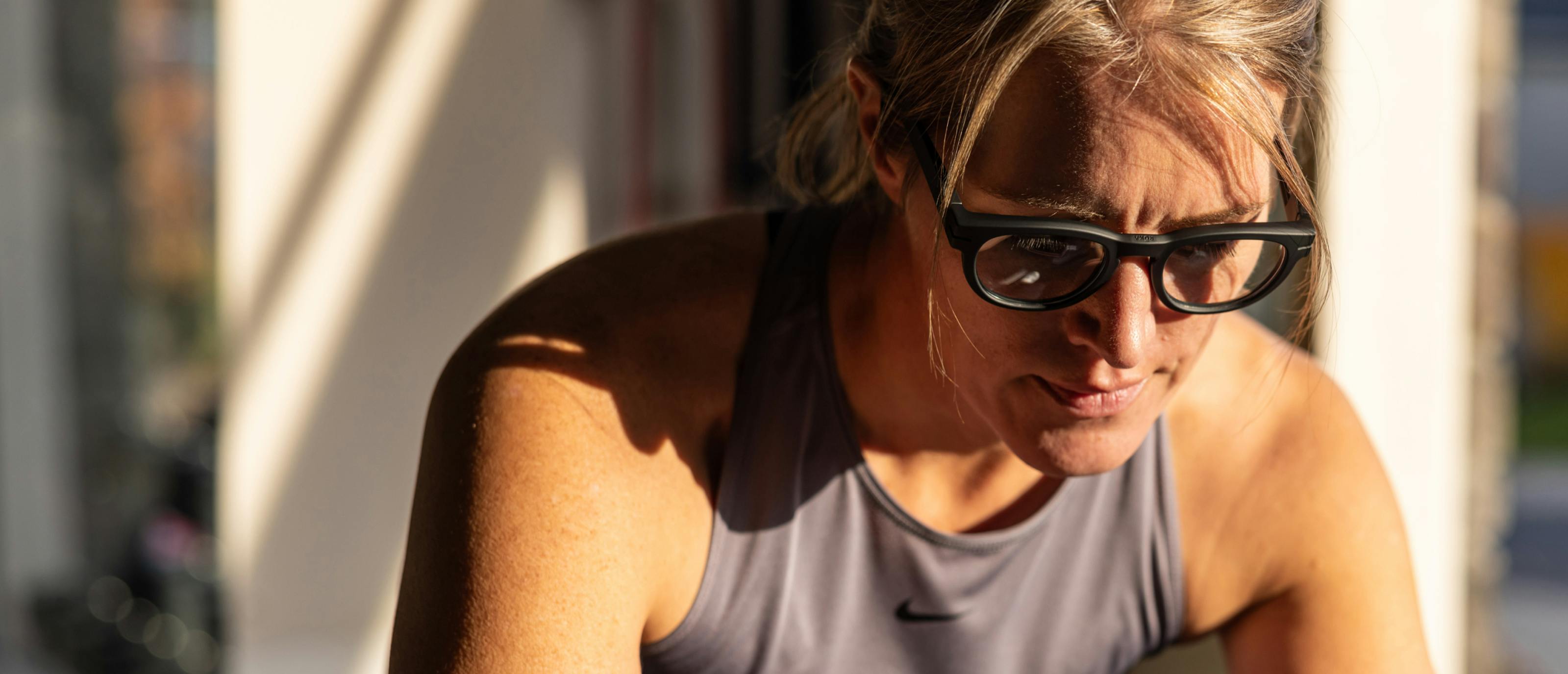 Woman wearing grey tank top and cooper eyeglasses