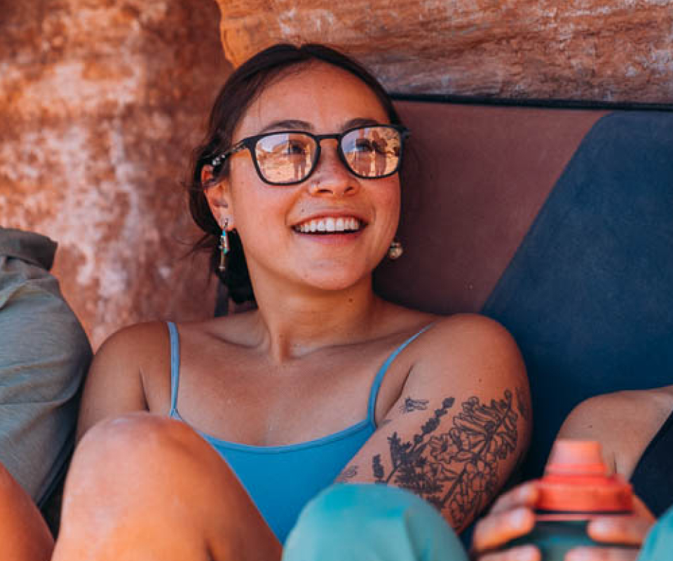 Woman with bouldering pad wearing Hunter eyeglasses