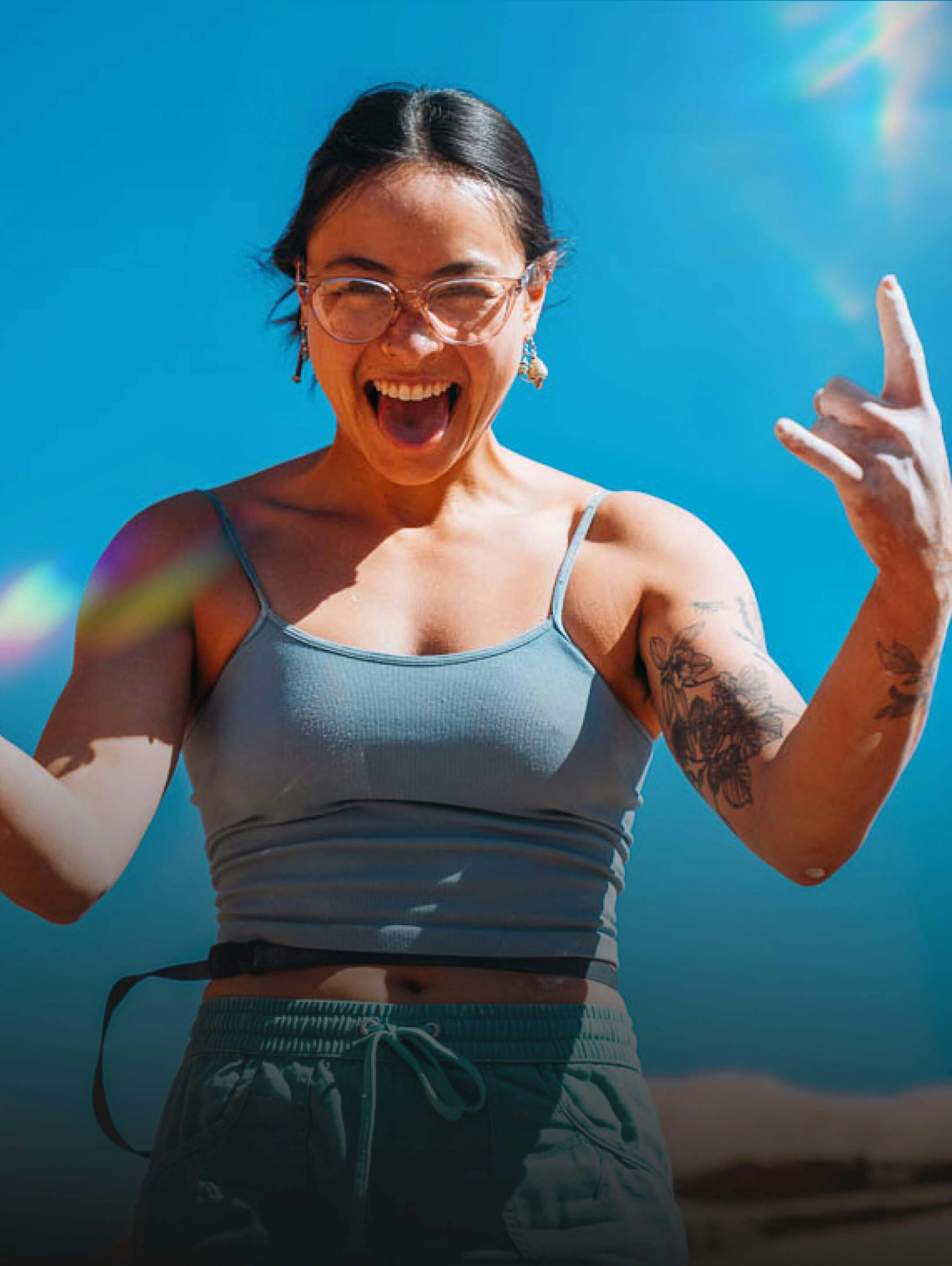 Woman on top of boulder wearing ROKA eyeglasses