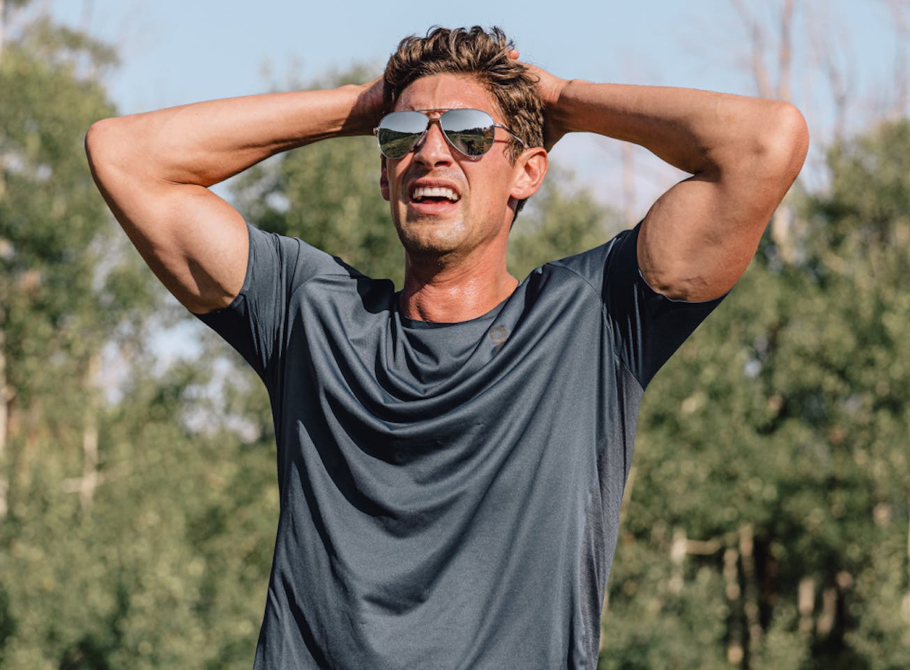 Man breathing with hands over head wearing Phantom sunglasses