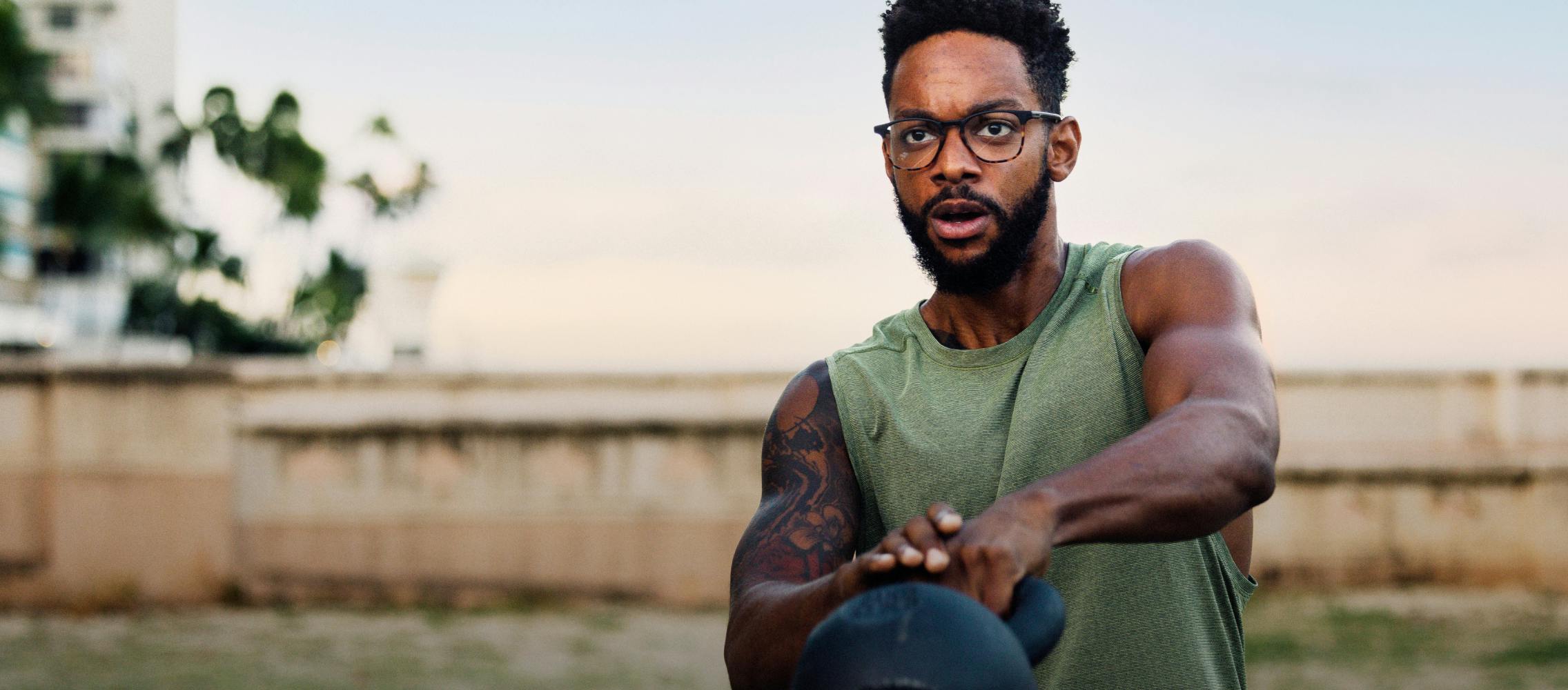 Man swinging kettlebell wearing ROKA eyeglasses