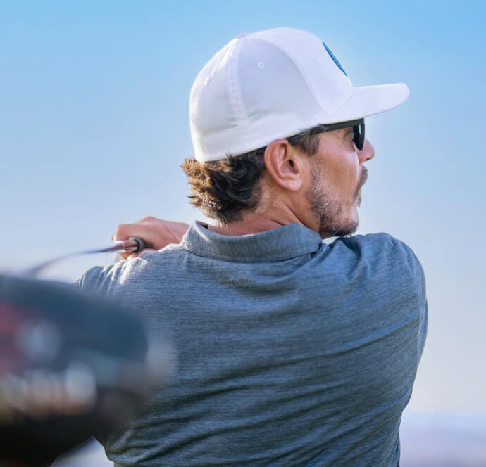 Man swinging driver on golf course