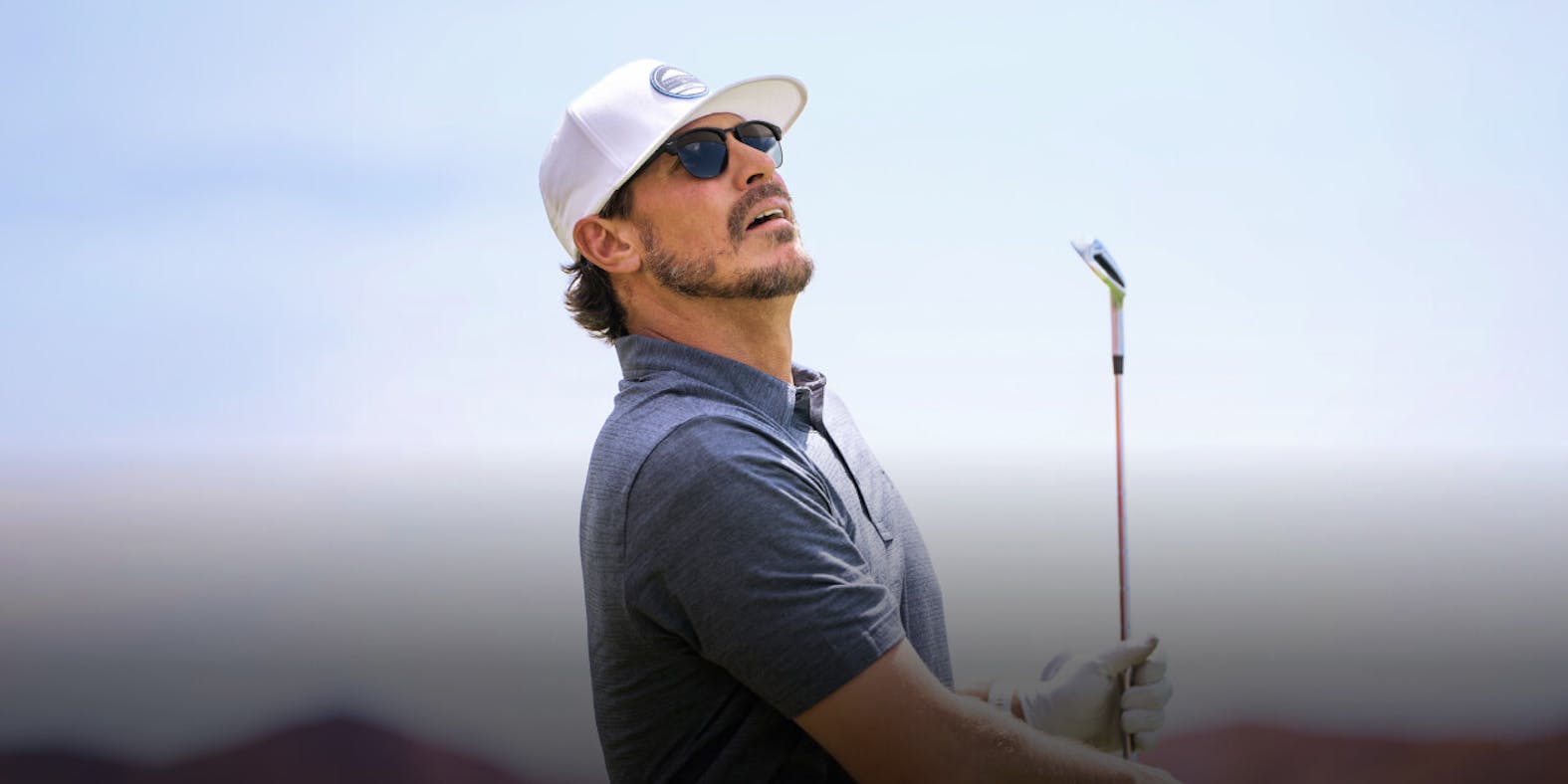 Man looking at golf shot after swing