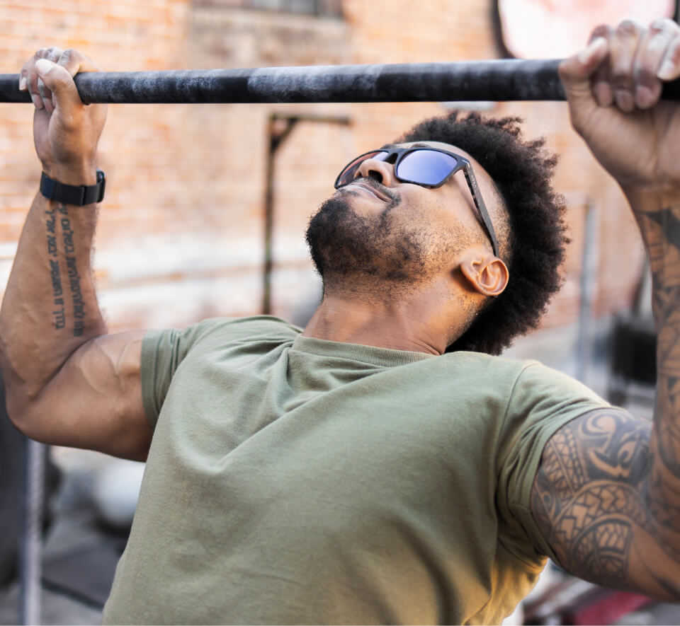 Man doing pull up wearing ROKA sunglasses