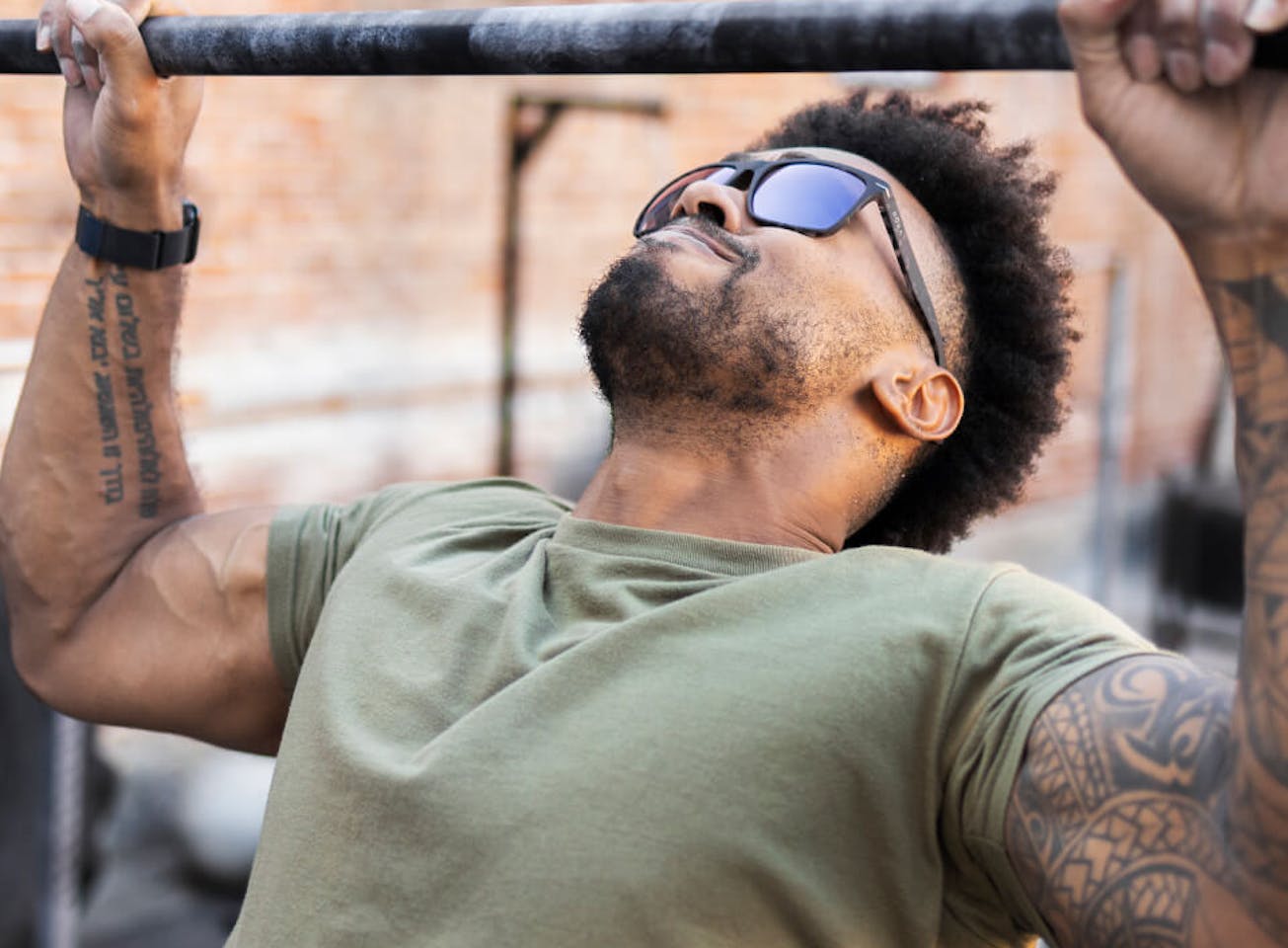 Man doing pull up wearing ROKA sunglasses