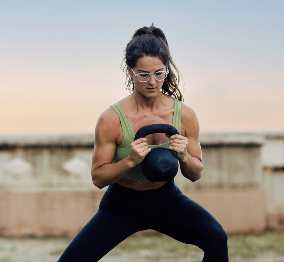 Man working out with kettle bell wearing ROKA eyeglasses