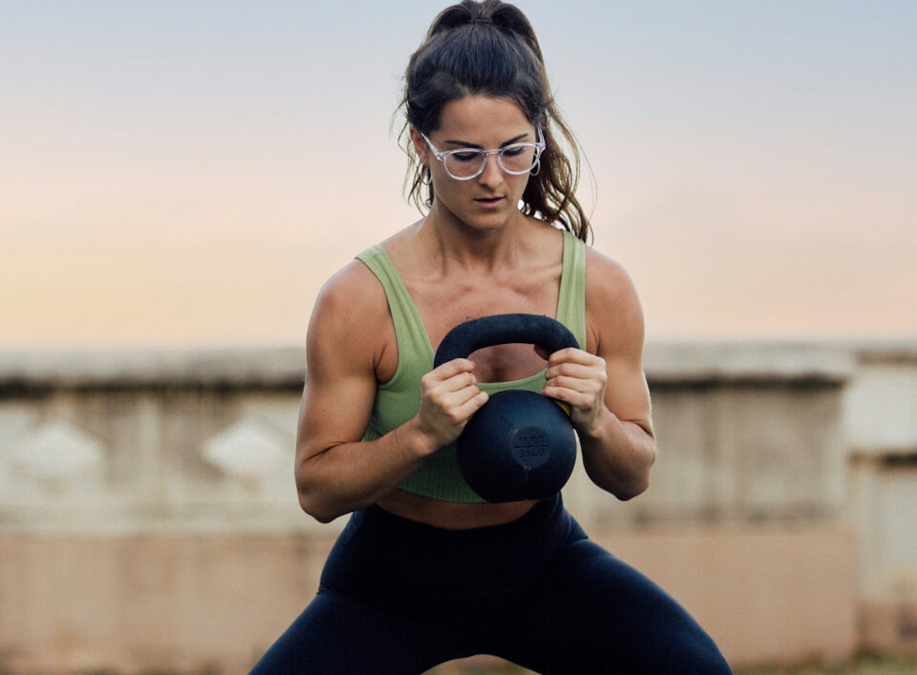 Man working out with kettle bell wearing ROKA eyeglasses