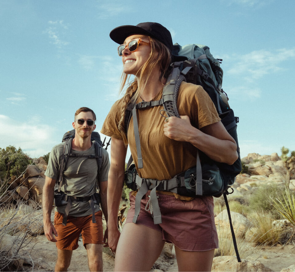 Man and woman backpacking wearing ROKA sunglasses