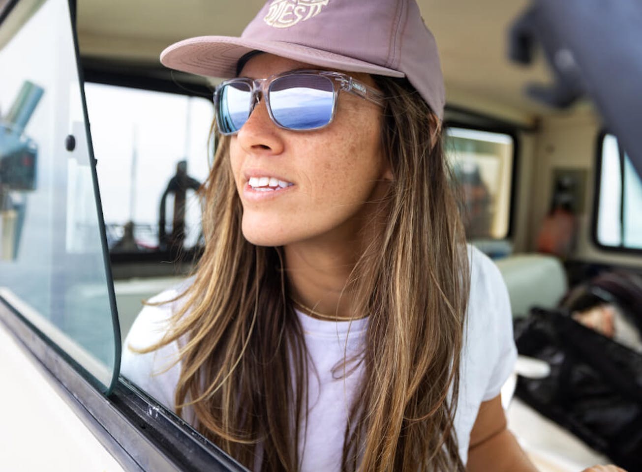 Woman wearing pink hat and ROKA mirrored sunglasses
