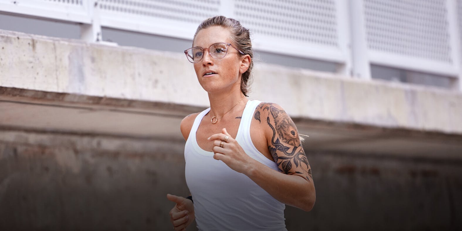 Woman running in white tank top and ROKA eyeglasses