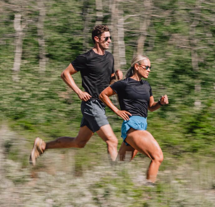 Woman and woman running in the woods