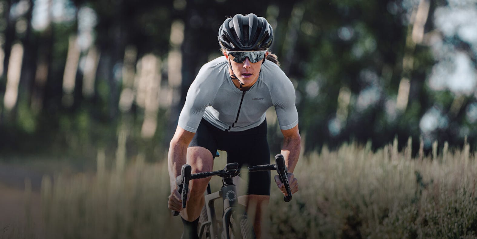Woman biking through tall grass