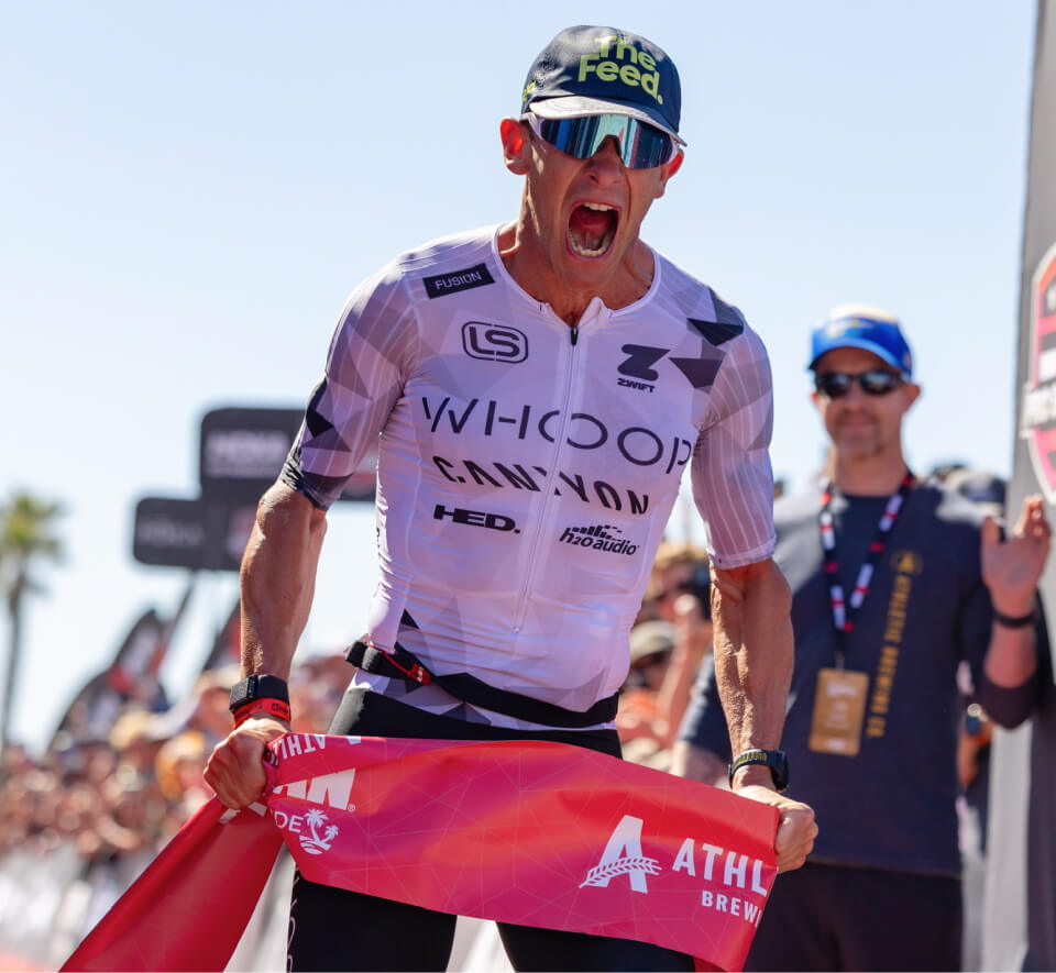 Man crossing finish line at triathlon