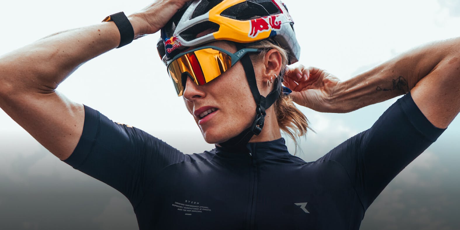 Woman wearing bike helmet and gold mirrored ROKA sunglasses