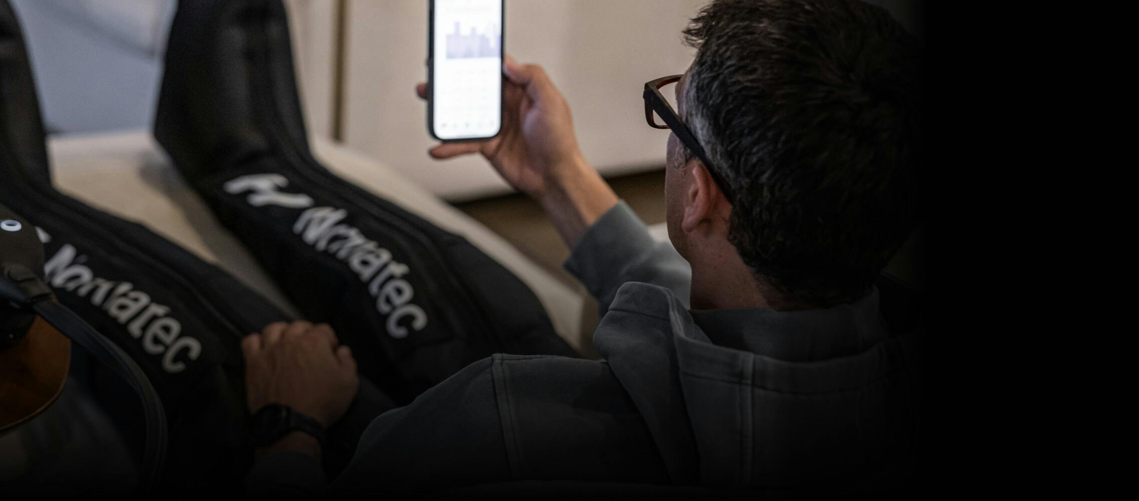 Man with compession leg sleeves on phone