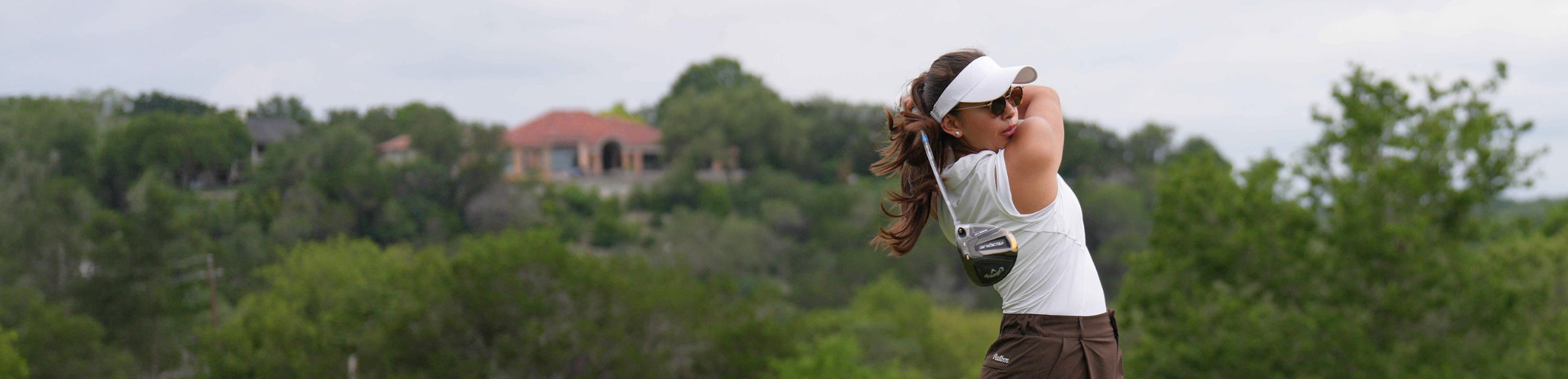 Woman swinging golf club driver