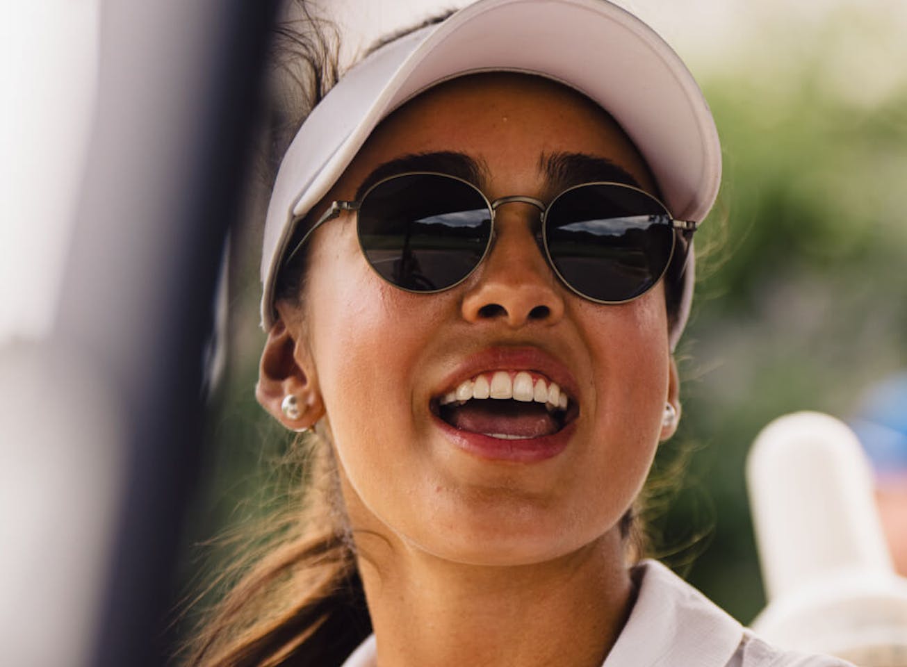 Woman wearing white golf hat and Alto Sunglasses