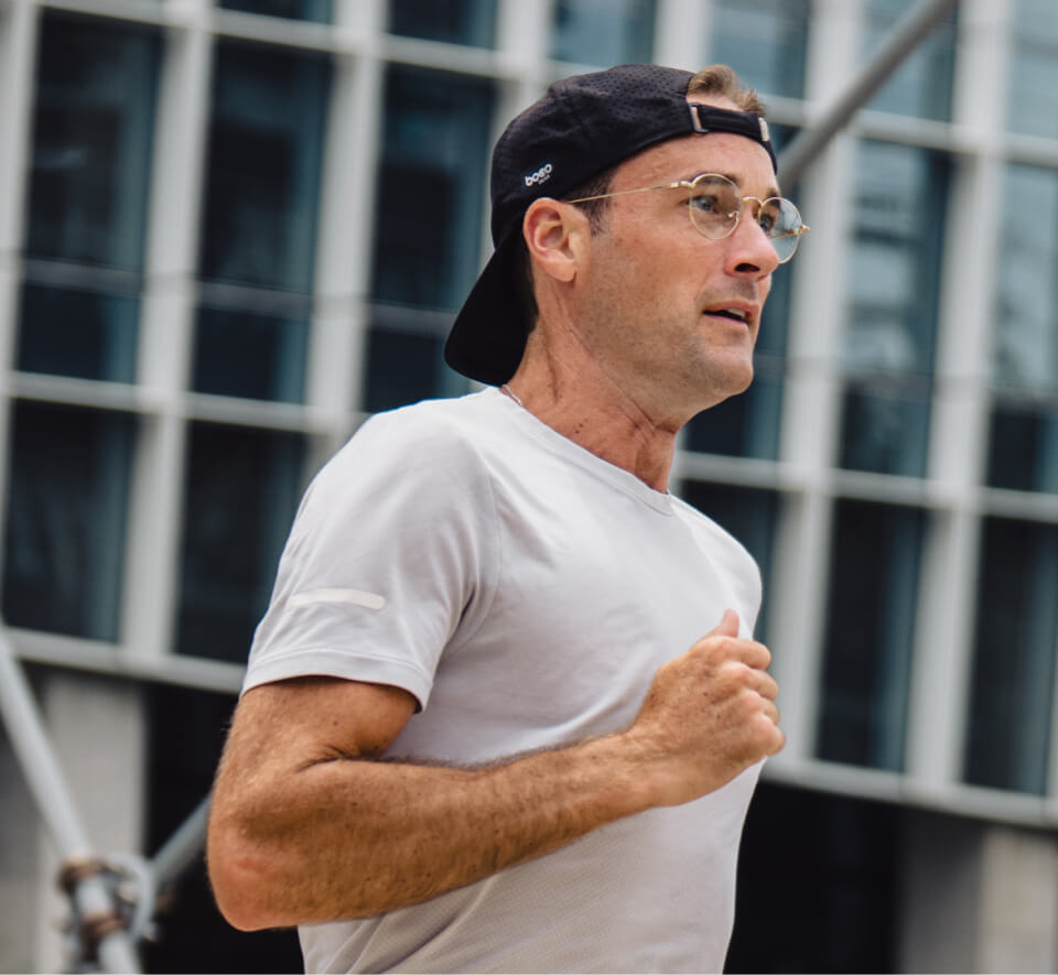 Man jogging in black hat and Alto Eyeglasses