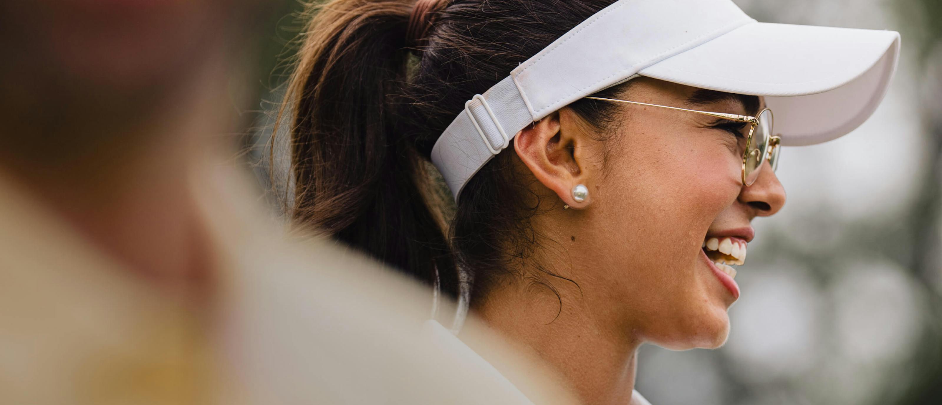 Woman wearing white golf hat and Alto Eyeglasses