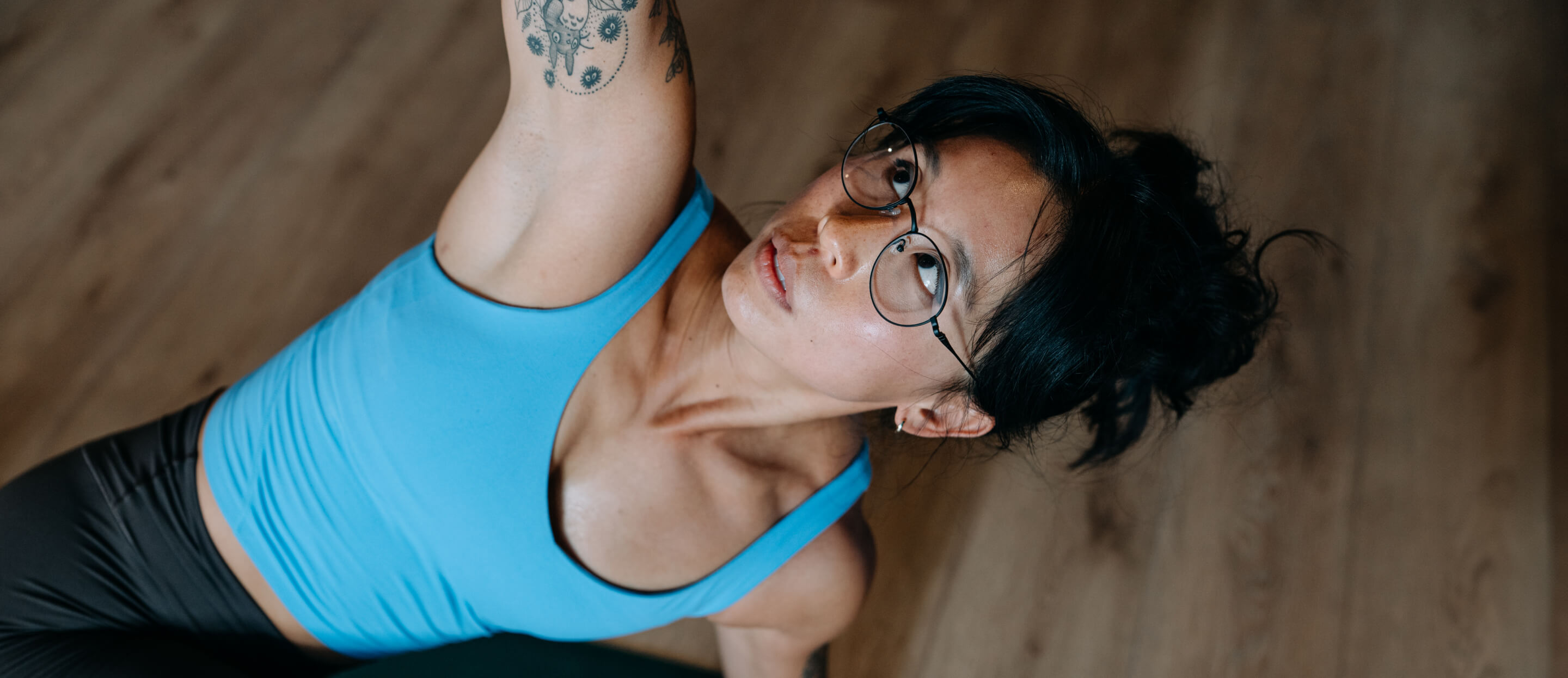 woman stretching in blue top and Alto Eyeglasses