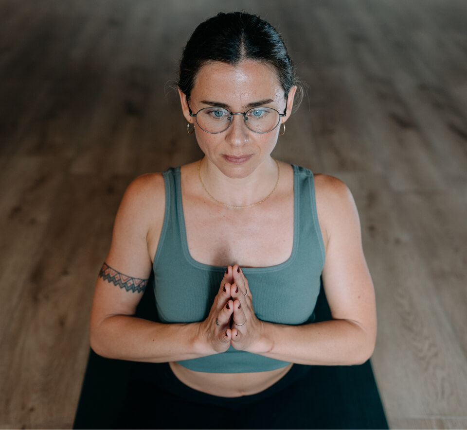 Woman doing yoga pose in green top and Alto Eyeglasses