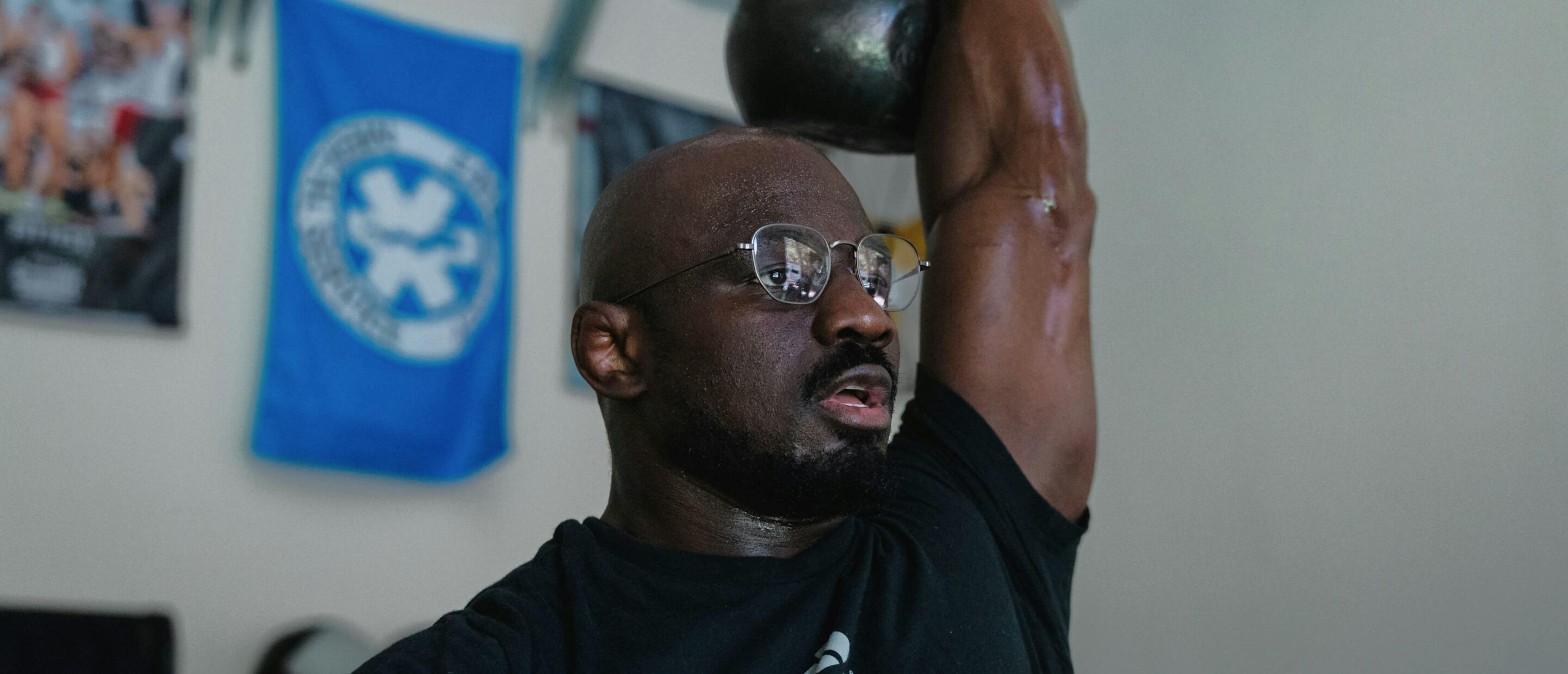 Man pressing kettle bell in Lyno Eyeglasses