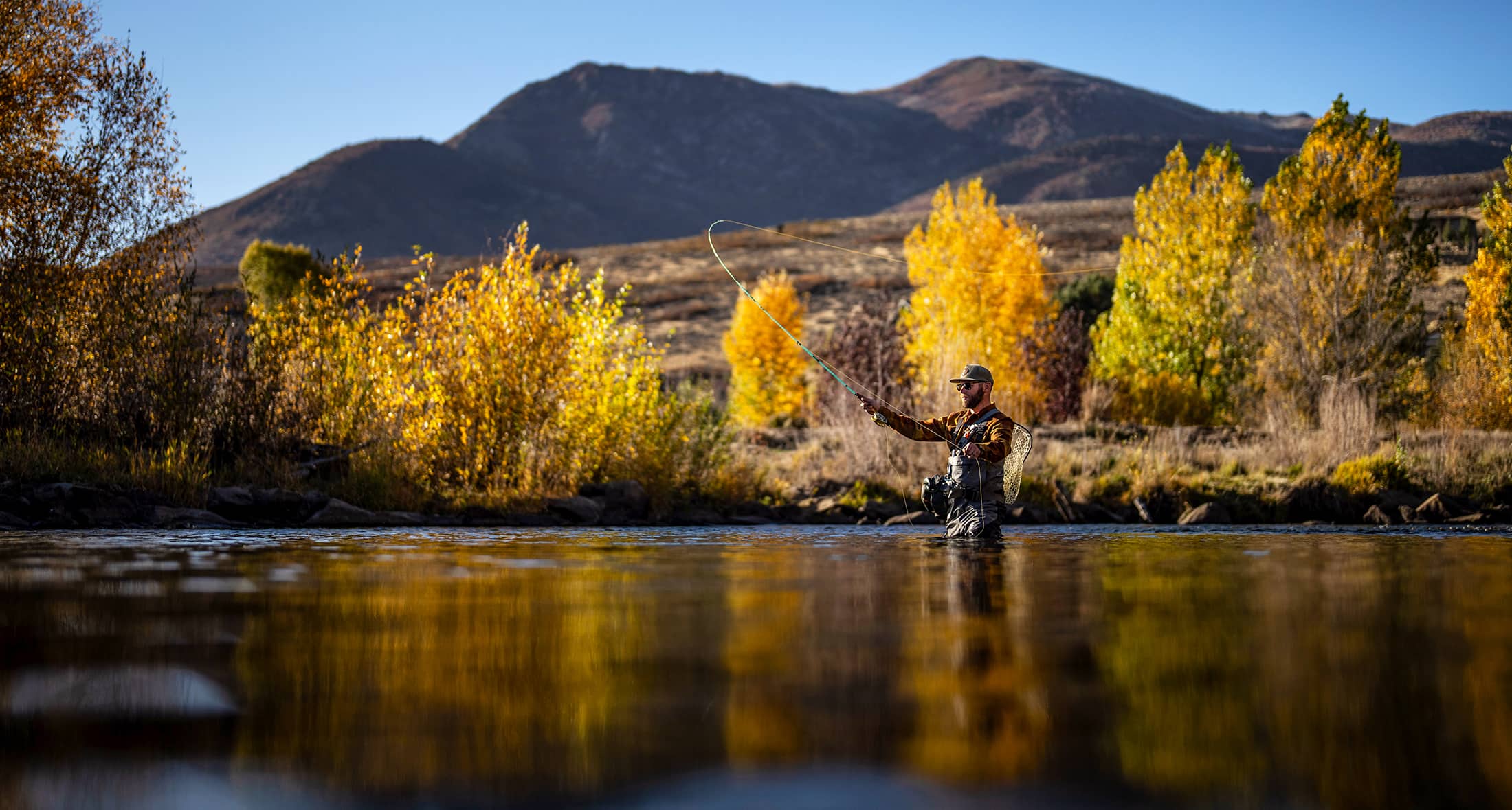 Man fly fishing in mountainous scene