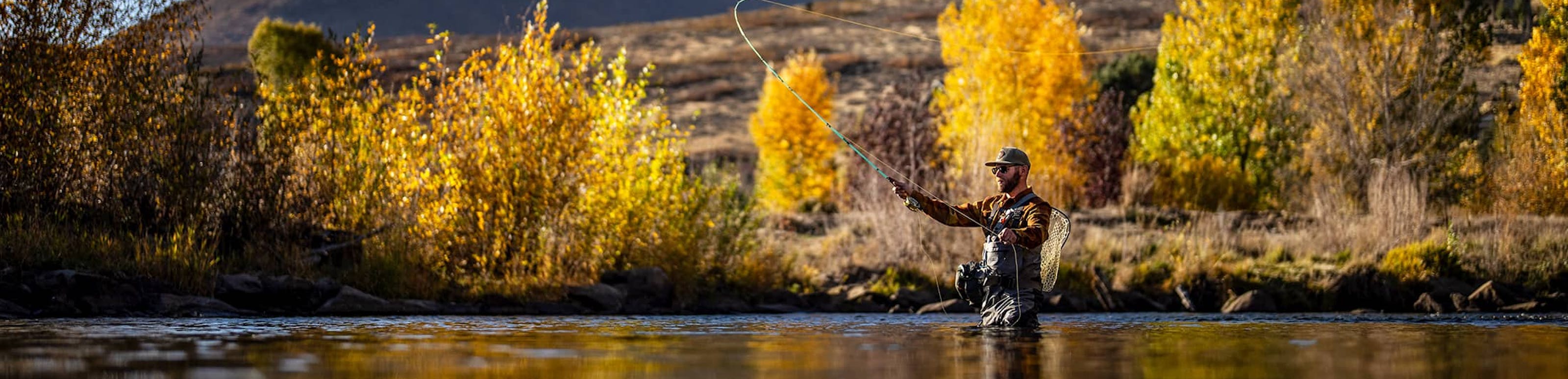 Man fly fishing in mountainous scene