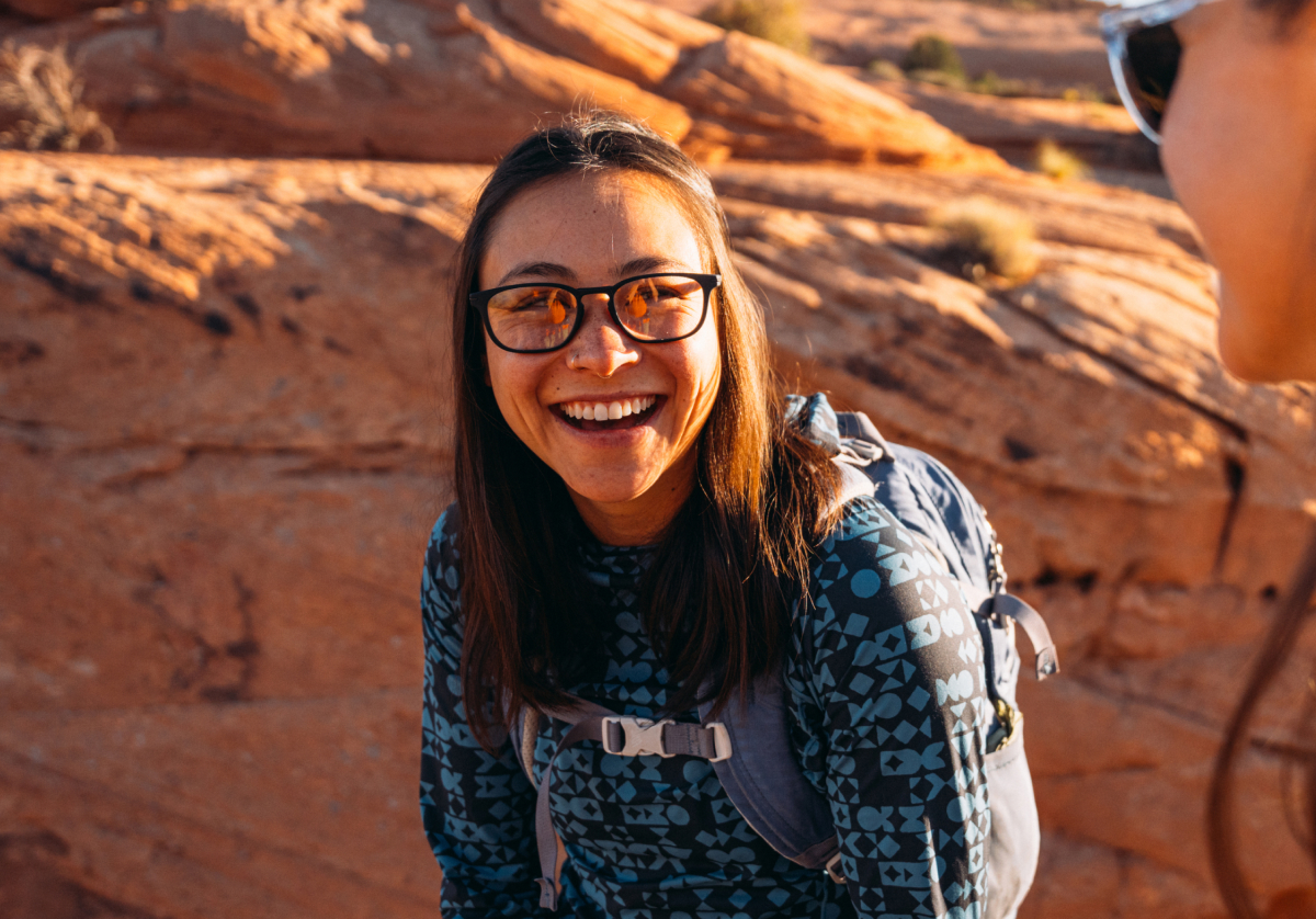 Woman smiling wearing rectangular, matte black Cade eyeglasses