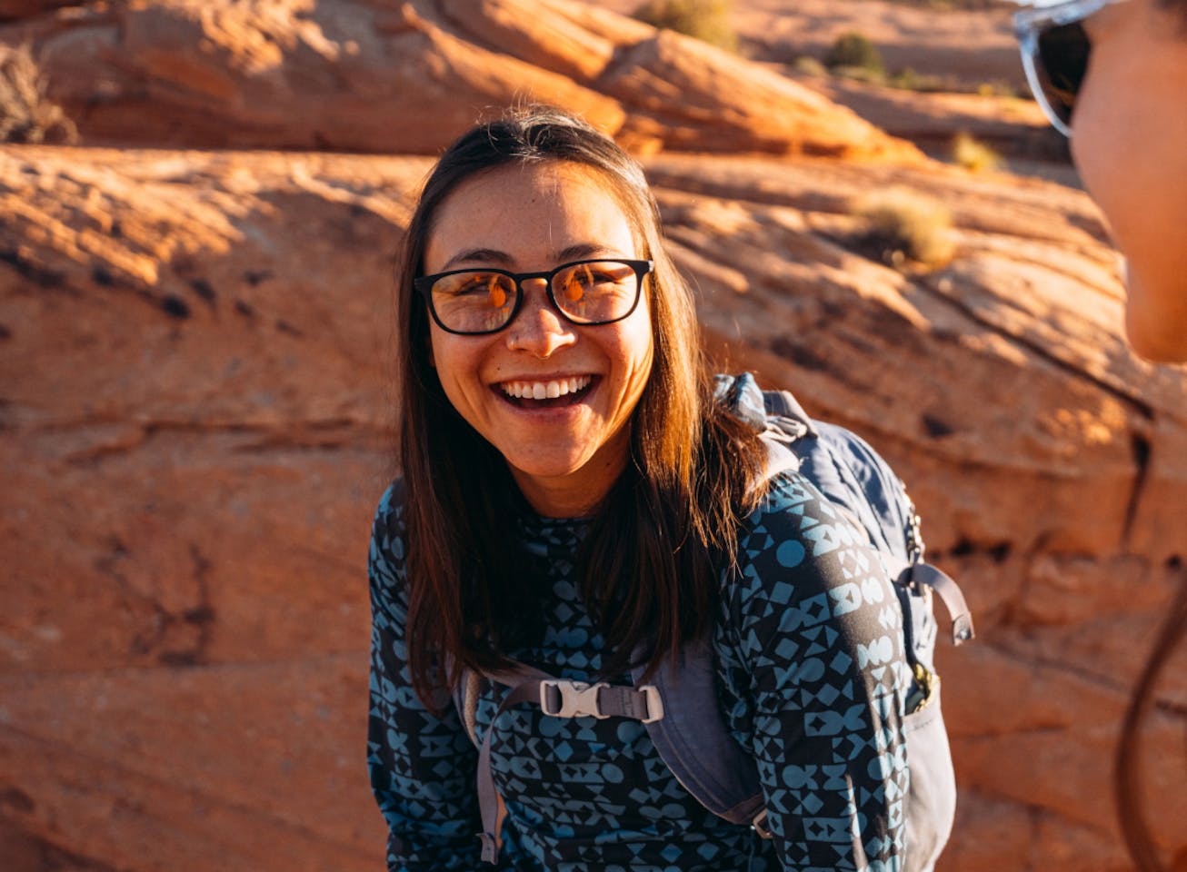 Woman smiling wearing rectangular, matte black Cade eyeglasses