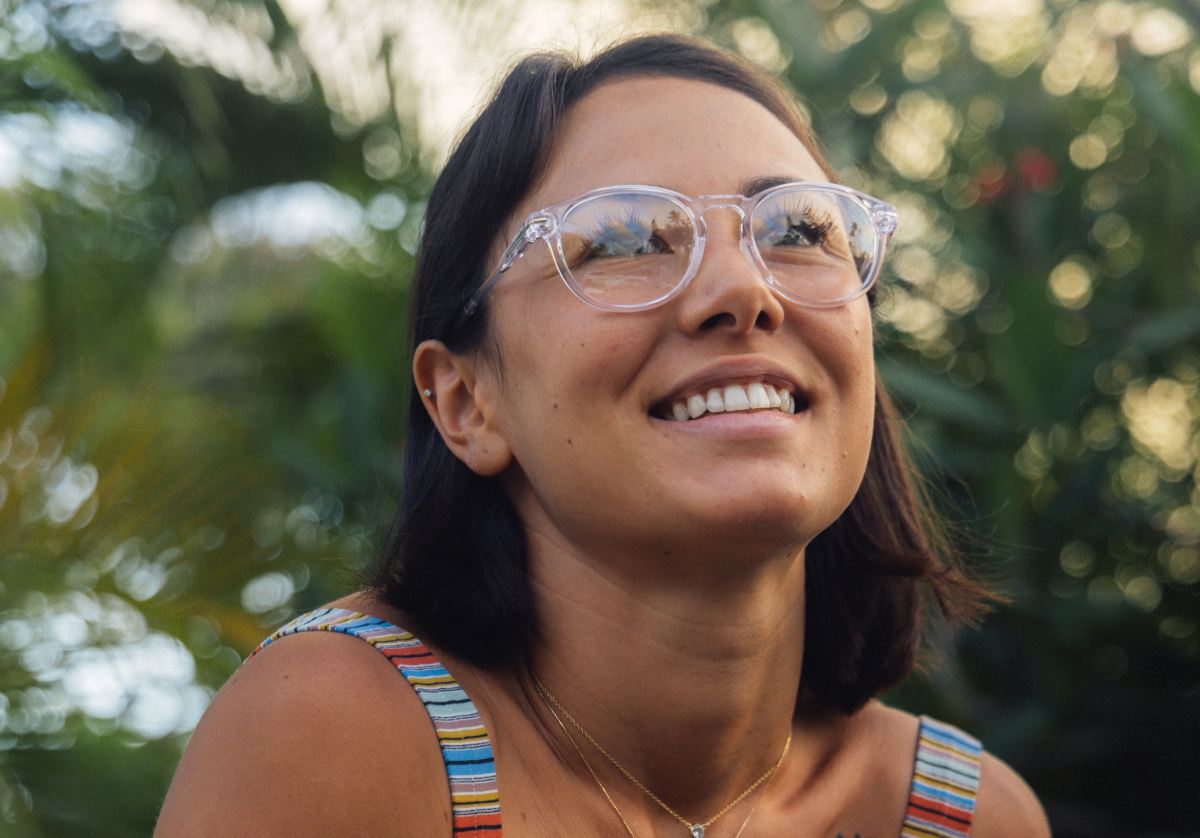 Woman smiling outside wearing round, clear frame Oslo eyeglasses