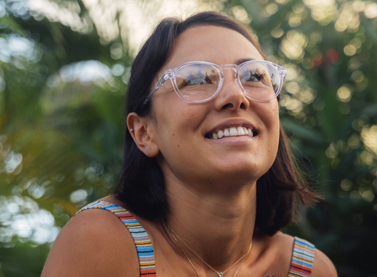 Woman smiling outside wearing round, clear frame Oslo eyeglasses