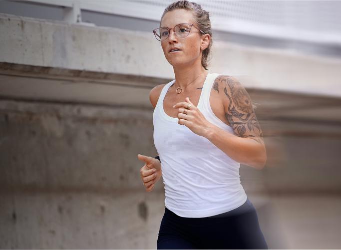 Woman jogging in white top and ROKA eyeglasses