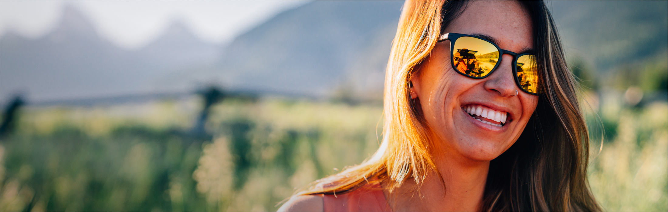 Woman smiling in the outdoors wearing ROKA sunglasses