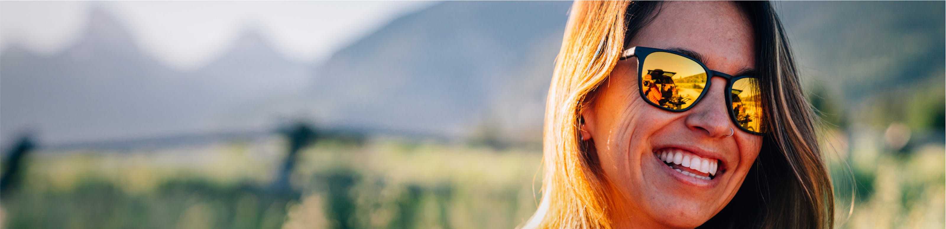 Woman smiling in the outdoors wearing ROKA sunglasses