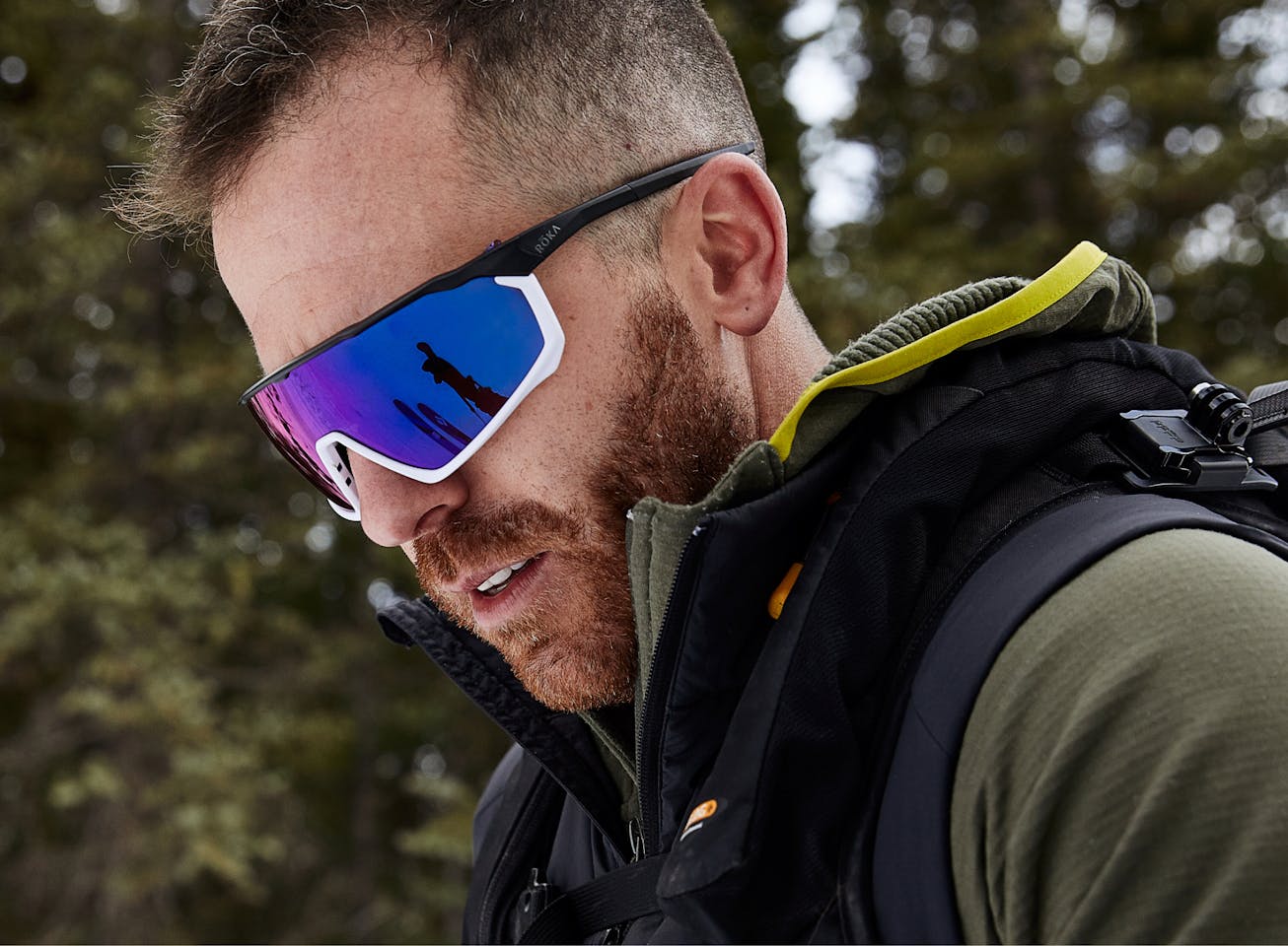 Man in the woods in a green jacket wearing CP-1x sunglasses