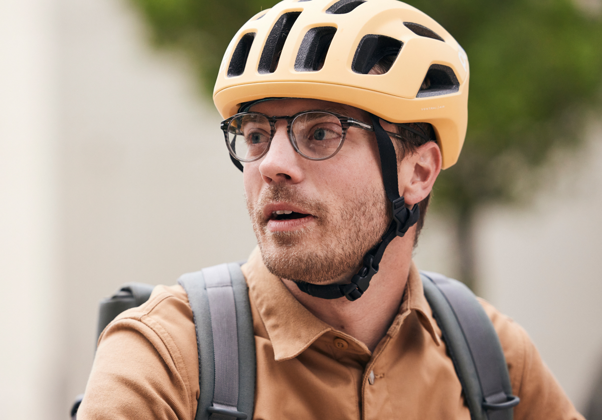 Man with bike helmet wearing round, matte black frame Oslo eyeglasses