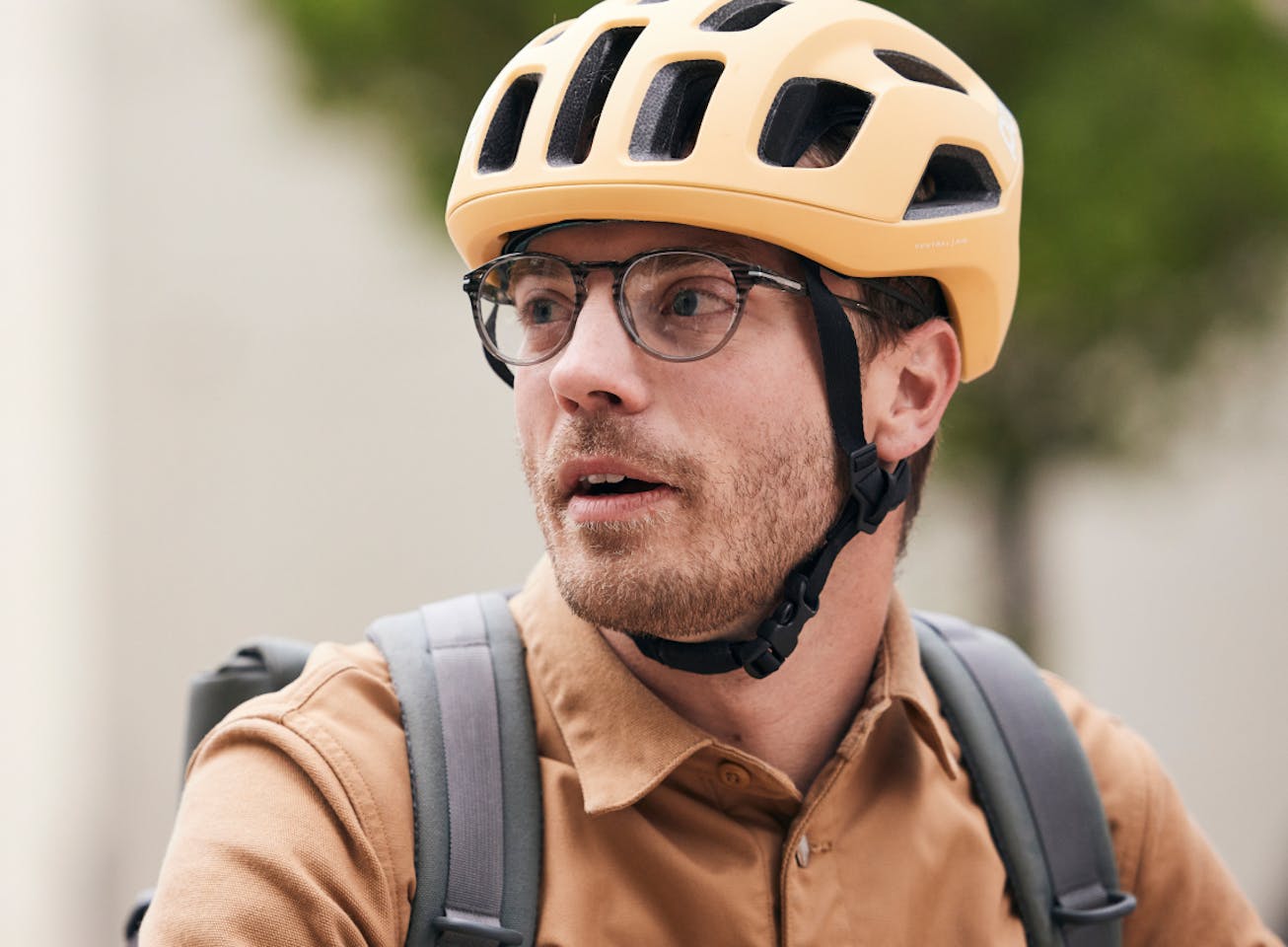 Man with bike helmet wearing round, matte black frame Oslo eyeglasses
